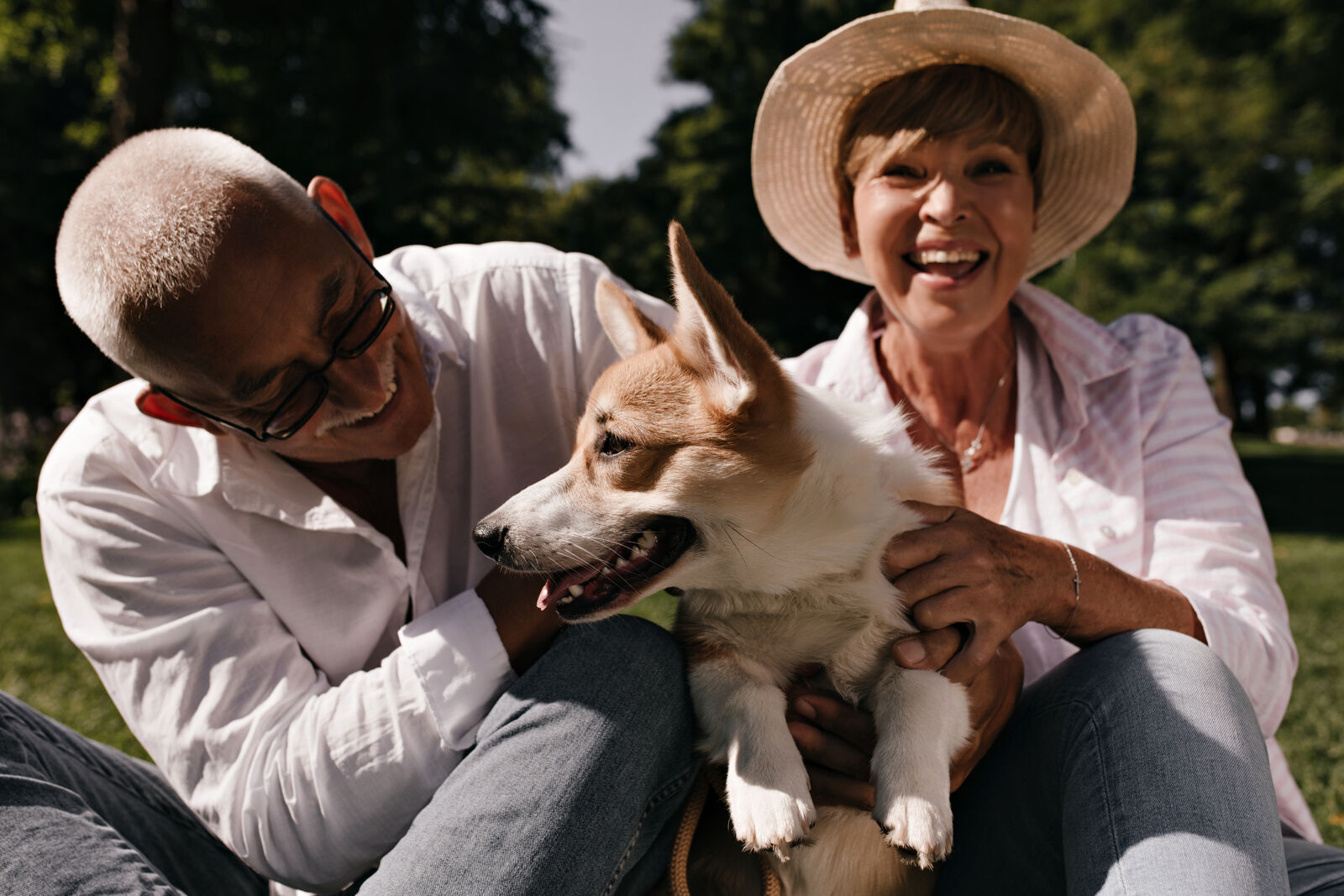 A smiling man and a woman holding a dog.