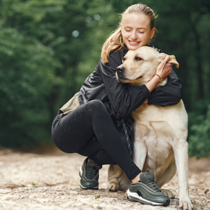 A girl hugging a large, light-colored dog